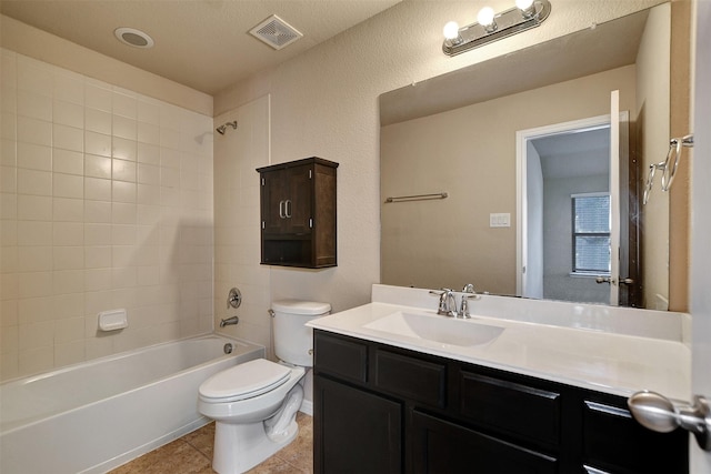 full bathroom featuring tile patterned floors, vanity, a textured ceiling, toilet, and tiled shower / bath