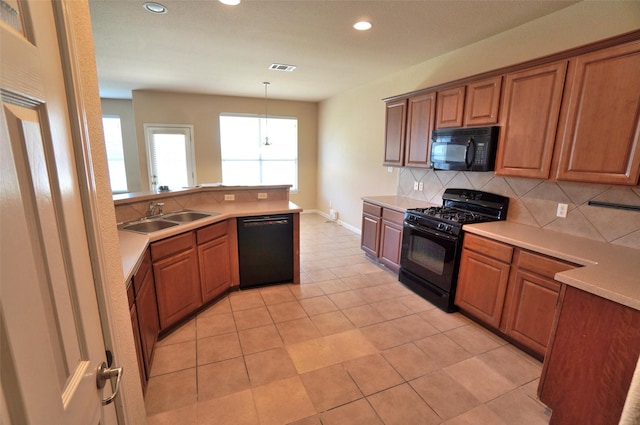 kitchen featuring pendant lighting, black appliances, sink, tasteful backsplash, and light tile patterned flooring