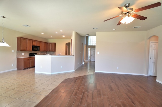 kitchen with backsplash, light hardwood / wood-style flooring, hanging light fixtures, and ceiling fan