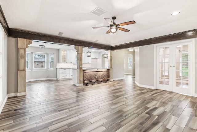 unfurnished living room featuring french doors, hardwood / wood-style flooring, and ceiling fan