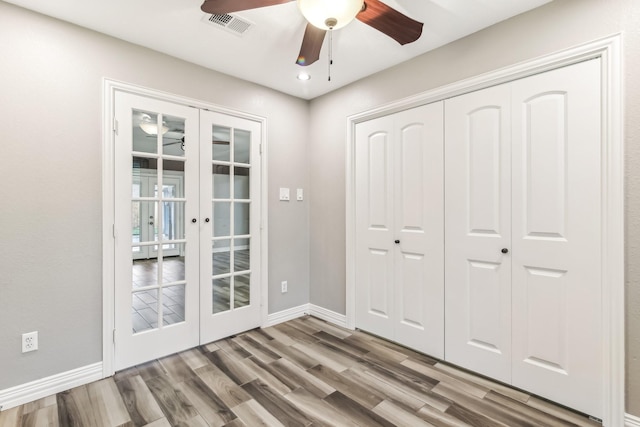 interior space with ceiling fan, french doors, and wood-type flooring