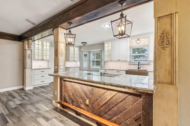 kitchen with white cabinetry, sink, dark wood-type flooring, and decorative light fixtures