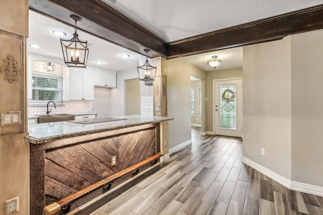 kitchen with a wealth of natural light, sink, white cabinets, and wood-type flooring