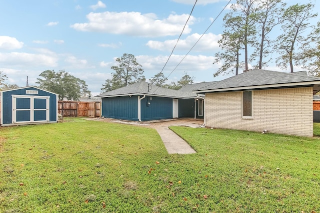 rear view of house with a lawn and a shed