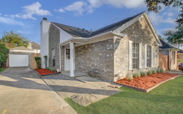 view of front of property featuring a garage, an outbuilding, and a front yard