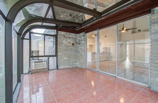 unfurnished sunroom featuring ceiling fan and cooling unit