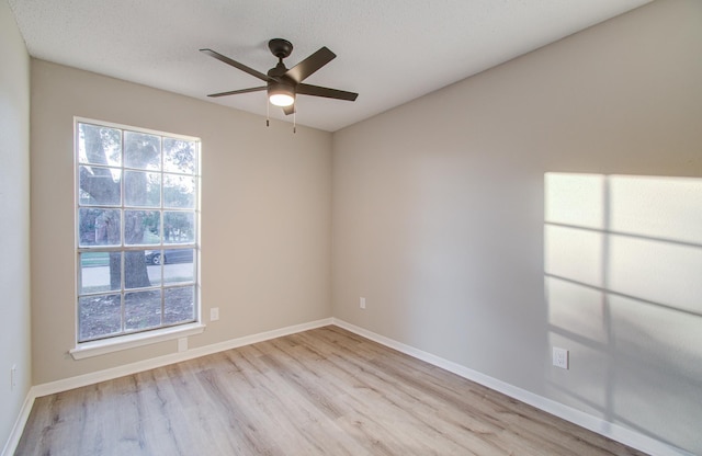 spare room featuring a textured ceiling, light hardwood / wood-style floors, and ceiling fan