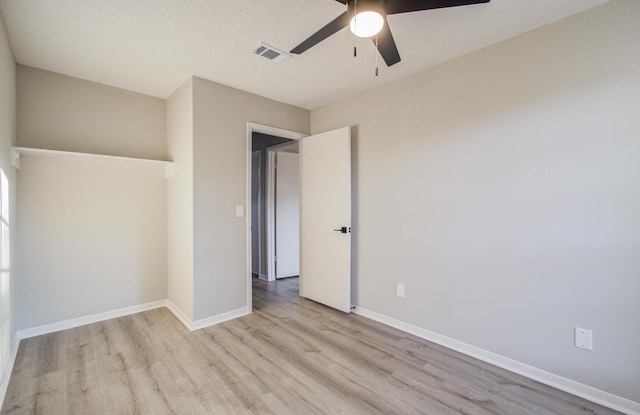 unfurnished bedroom featuring ceiling fan, light hardwood / wood-style floors, and a textured ceiling