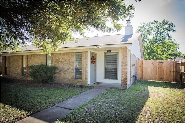 single story home featuring a front lawn