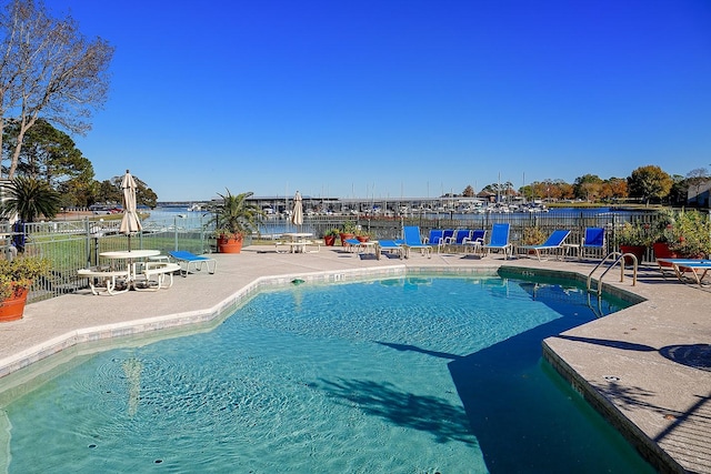 view of swimming pool with a patio and a water view