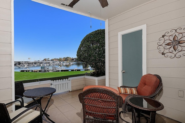 balcony with ceiling fan and a water view