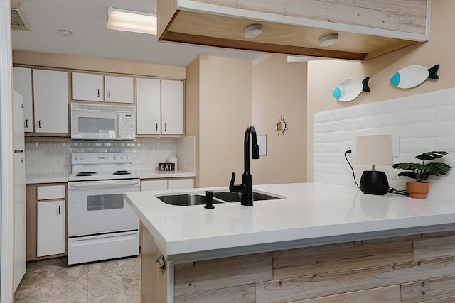 kitchen with kitchen peninsula, sink, white cabinets, and white appliances