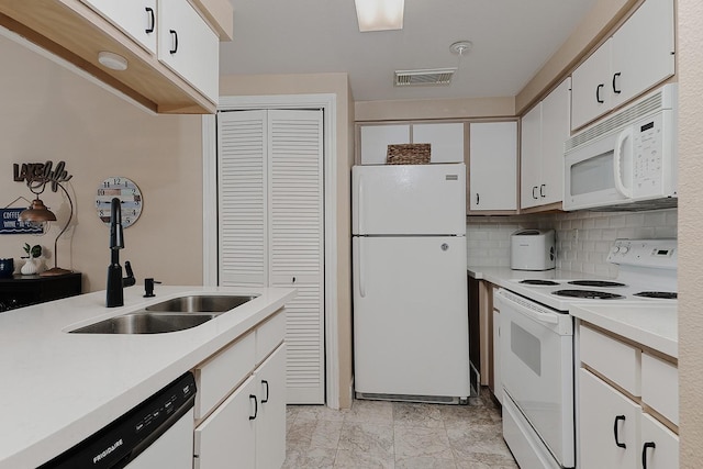 kitchen with tasteful backsplash, sink, white cabinets, and white appliances