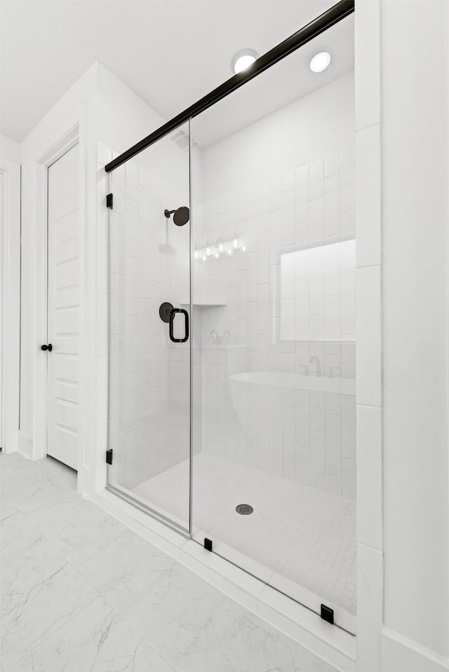 bathroom with a shower with door