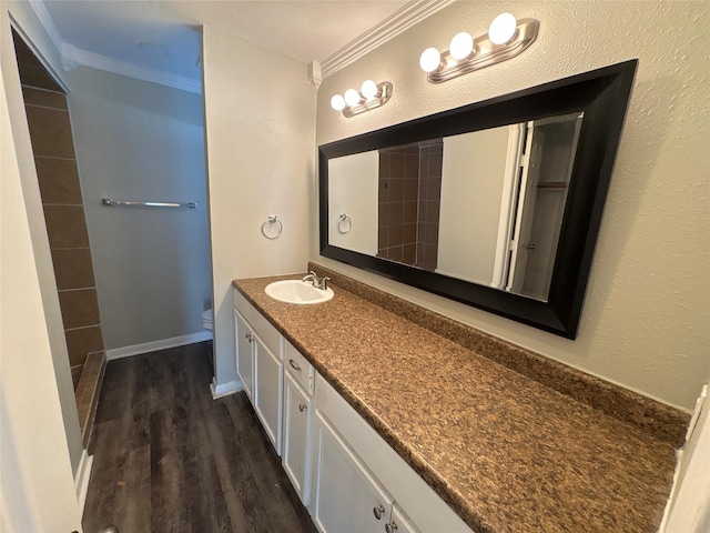 bathroom with toilet, vanity, ornamental molding, and hardwood / wood-style flooring