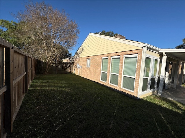 view of side of home featuring a yard and a patio