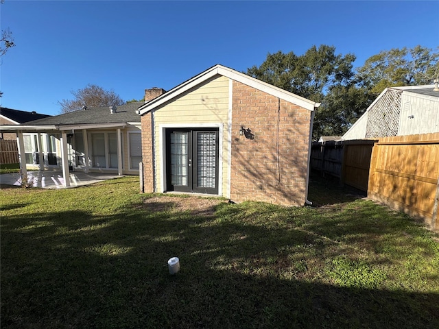 rear view of house featuring a patio area and a lawn