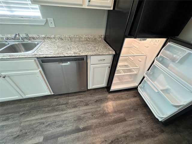 kitchen featuring light stone countertops, white cabinetry, sink, stainless steel dishwasher, and dark hardwood / wood-style floors