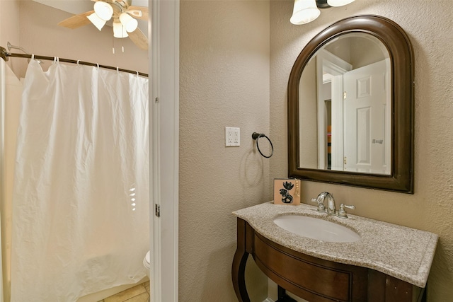 bathroom featuring walk in shower, ceiling fan, vanity, and toilet