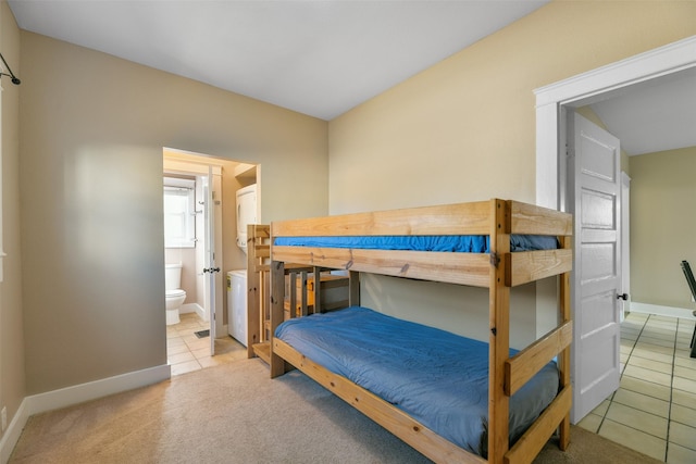 bedroom featuring light carpet and ensuite bath