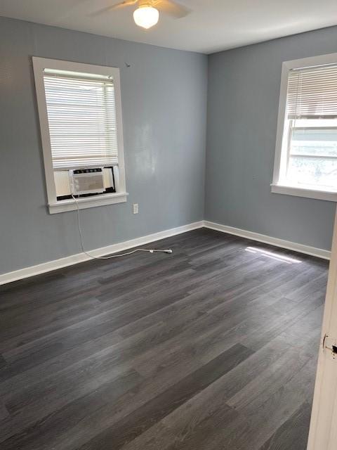 unfurnished room with dark hardwood / wood-style floors, ceiling fan, and cooling unit