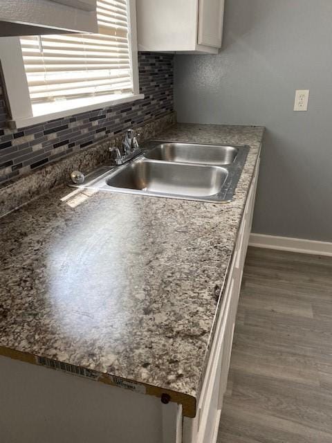 kitchen featuring tasteful backsplash, white cabinetry, sink, and dark wood-type flooring