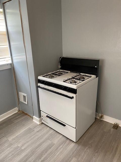 kitchen with white gas range and light hardwood / wood-style flooring