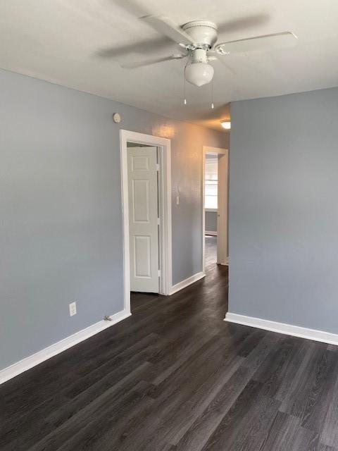 empty room with ceiling fan and dark hardwood / wood-style flooring