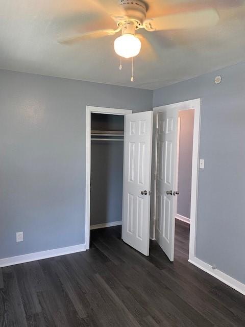 unfurnished bedroom featuring dark hardwood / wood-style flooring, a closet, and ceiling fan