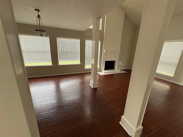 unfurnished living room featuring dark hardwood / wood-style floors and a brick fireplace