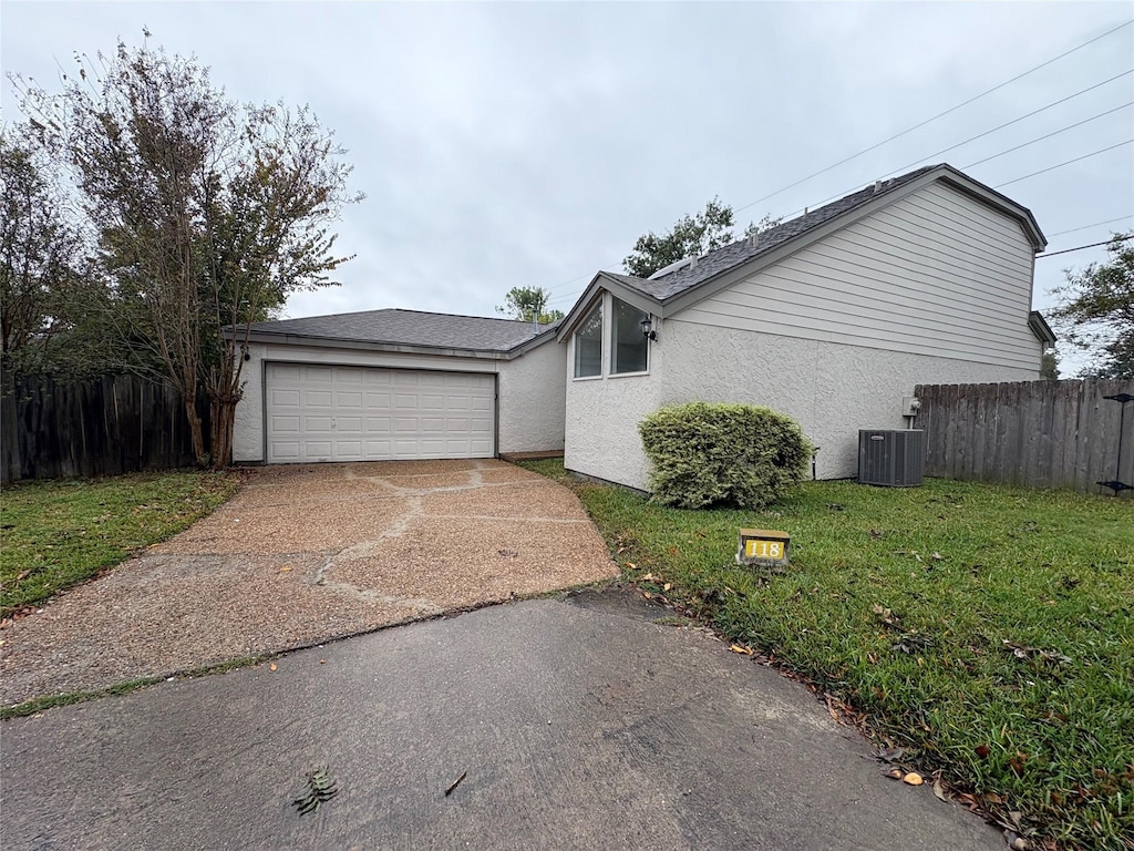 ranch-style home with central AC unit, a front yard, and a garage