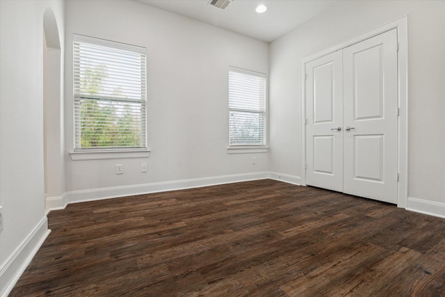 unfurnished bedroom featuring dark hardwood / wood-style floors and a closet