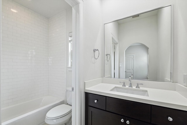 full bathroom with vanity, tiled shower / bath combo, and toilet