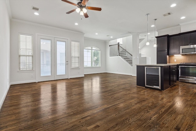 kitchen with pendant lighting, dark hardwood / wood-style floors, crown molding, and appliances with stainless steel finishes