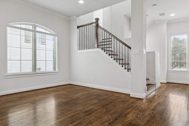 stairway with wood-type flooring, plenty of natural light, and crown molding