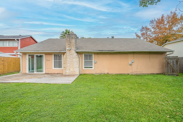 rear view of house with a lawn and a patio