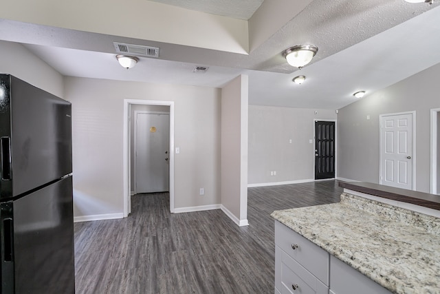 kitchen with dark hardwood / wood-style flooring, black refrigerator with ice dispenser, light stone counters, a textured ceiling, and white cabinets