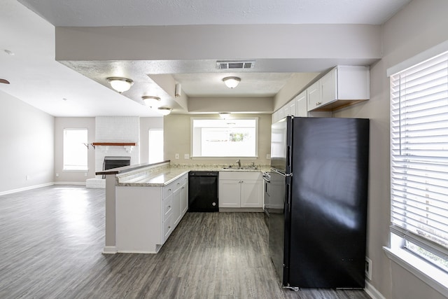 kitchen featuring kitchen peninsula, white cabinetry, plenty of natural light, and black appliances