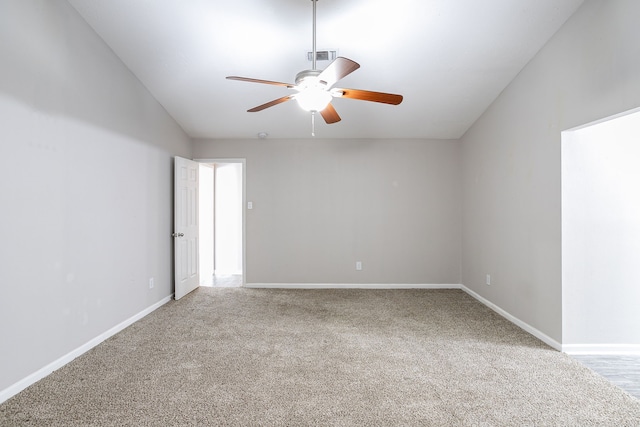 carpeted spare room featuring ceiling fan and vaulted ceiling