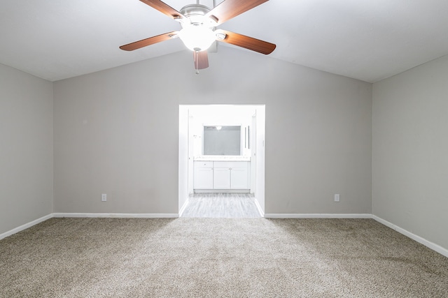 carpeted spare room featuring ceiling fan and vaulted ceiling