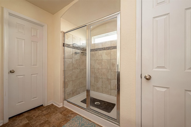 bathroom with a shower with door