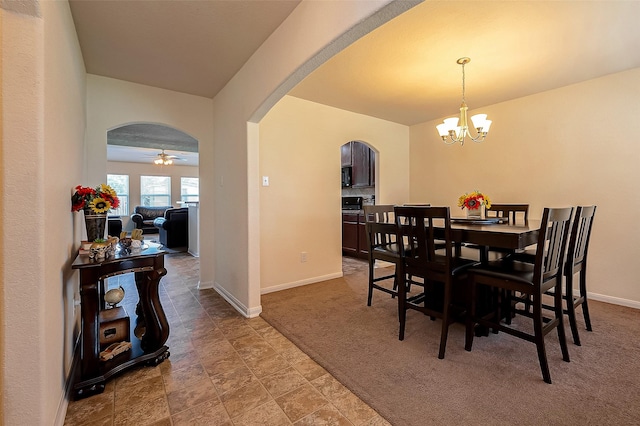 dining space featuring light carpet and ceiling fan with notable chandelier