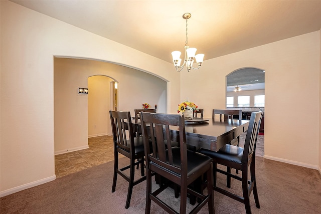 carpeted dining area featuring ceiling fan with notable chandelier