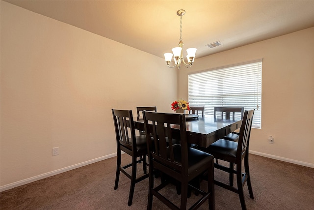 carpeted dining area with an inviting chandelier