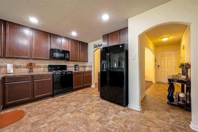 kitchen with black appliances, decorative backsplash, dark brown cabinets, and a textured ceiling