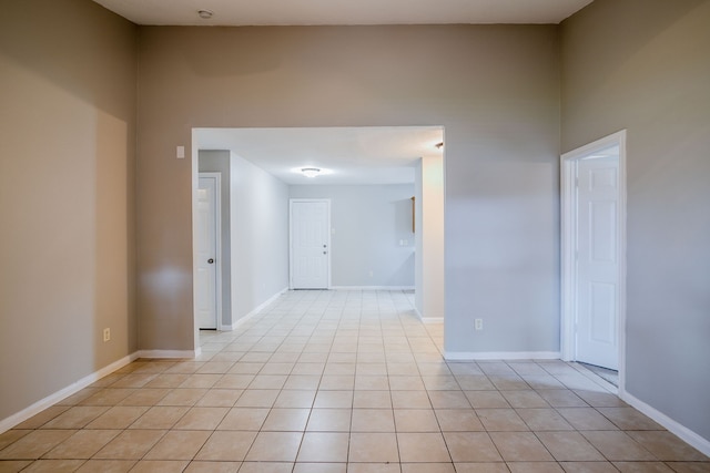 spare room featuring light tile patterned flooring and a high ceiling