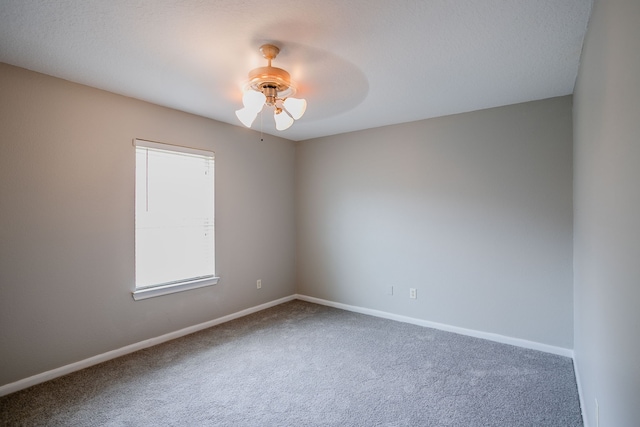 carpeted spare room featuring ceiling fan