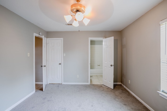 unfurnished bedroom with ensuite bath, ceiling fan, a closet, and light colored carpet