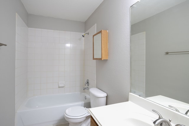 full bathroom featuring vanity, tiled shower / bath combo, and toilet