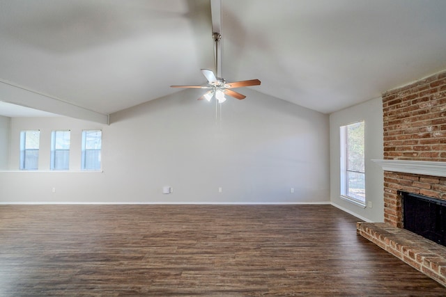 unfurnished living room featuring a wealth of natural light, dark hardwood / wood-style floors, lofted ceiling, and a brick fireplace